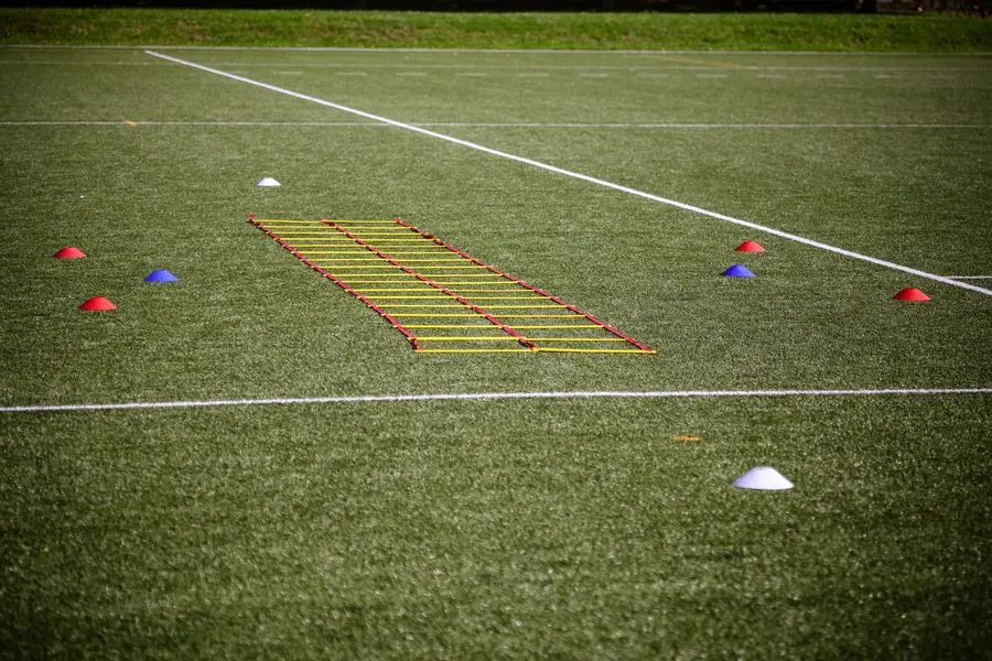 Agility ladder and marker cones laid out on a football field