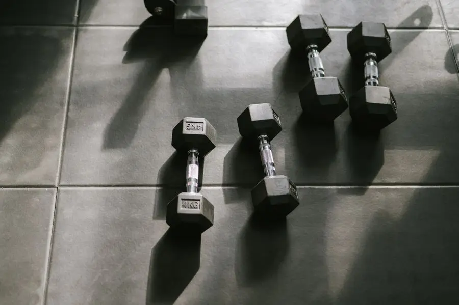 Hex dumbbells resting on a gym floor in daylight